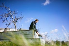 young asian Girl in sport clothing sits on wooden stairs outdoor