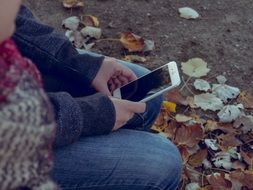 man sitting in the park with iPhone