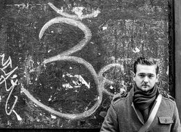 Black and white photo of the young man near the wall