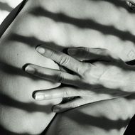 black and white photo of a hand on the body under the shadow