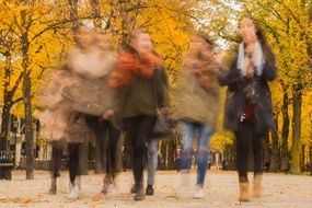 people on autumn walk in blurry background