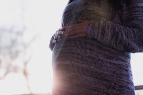 hands on the belly of a pregnant woman