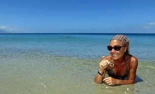 happy Woman Sunbathing on Beach at Water