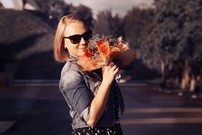 Young woman with the flowers in summer