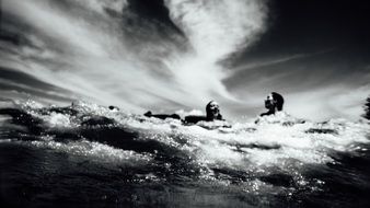 black and white photo of a girl swim in the ocean
