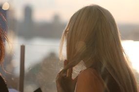 blonde girl with long hair in the rays of the evening sun