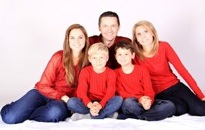 happy caucasian family with three Kids sitting on floor