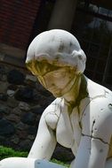 Woman, damaged stone sculpture outdoors