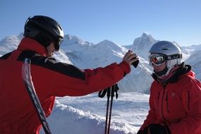 photo of skiers in the mountains on a sunny day