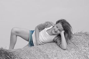 young girl on the straw bale