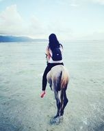 Woman on horse on the beach in Bali