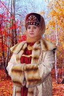 beautiful young girl in traditional russian clothing at colorful Autumn Forest