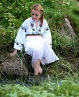 peasant woman sitting on green grass