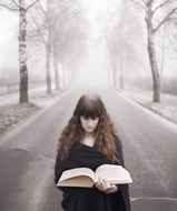 young long haired Girl with Book on Fogg Winter Road
