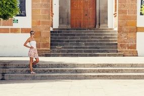 girl posing on the stairs near the house