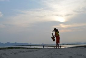 photo of girl with saxophone on the beach
