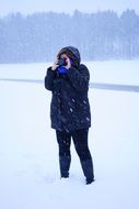 woman taking photo on snowy weather