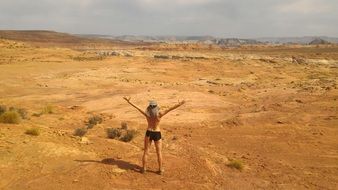 woman with hands up in the desert