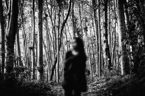 black and white photo of a girl in the forest