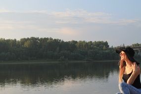 photo of a girl in a black hat on the lake