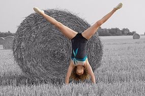 girl standing on her hand on the filed