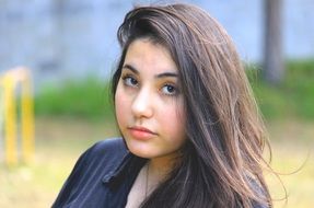 portrait of a girl with long hair on a blurry green background