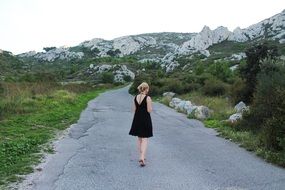 girl in black dress on Mountain Road, back view