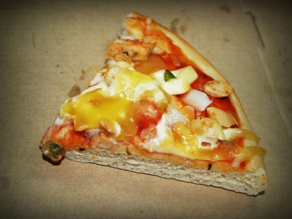 a piece of pizza on a cardboard box