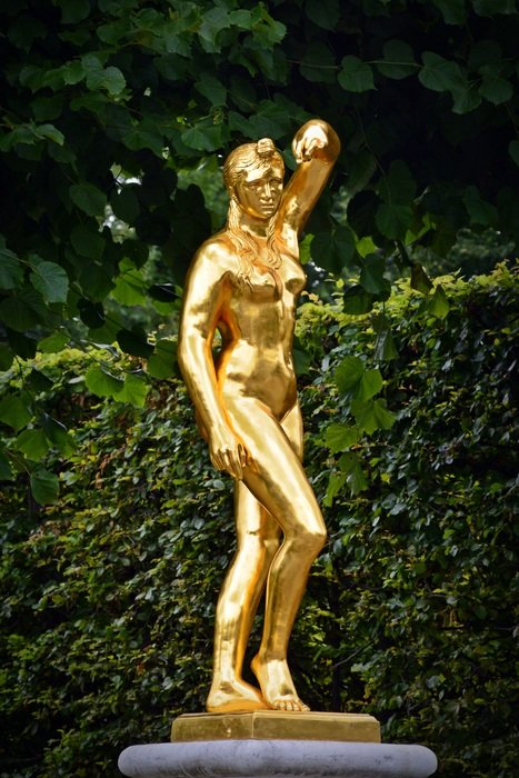 golden sculpture of a woman in the garden