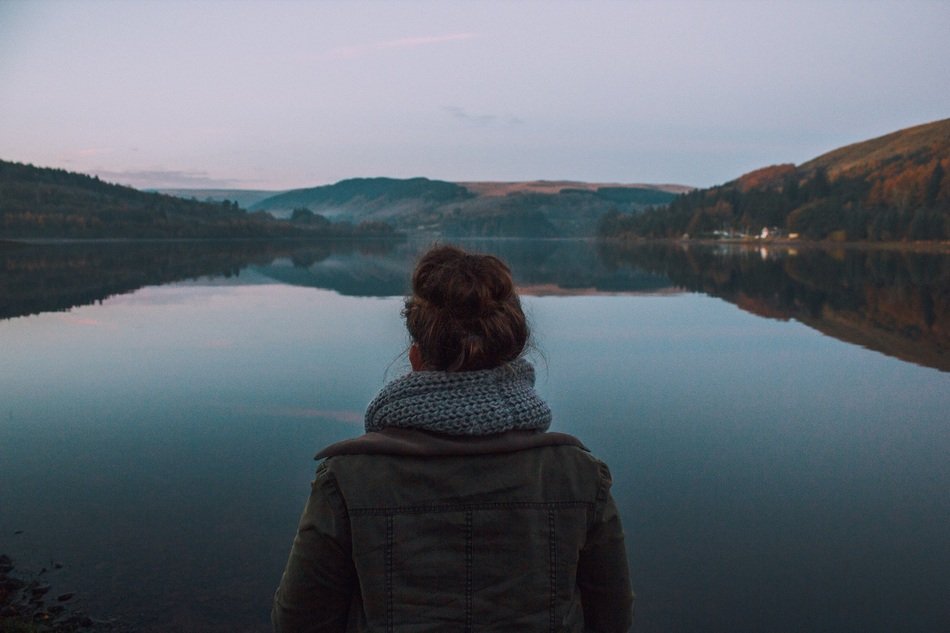 girl stands on the lake and looks at him