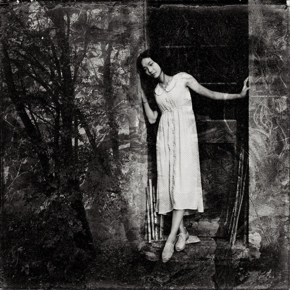 Black and white photo of the woman in the dark forest
