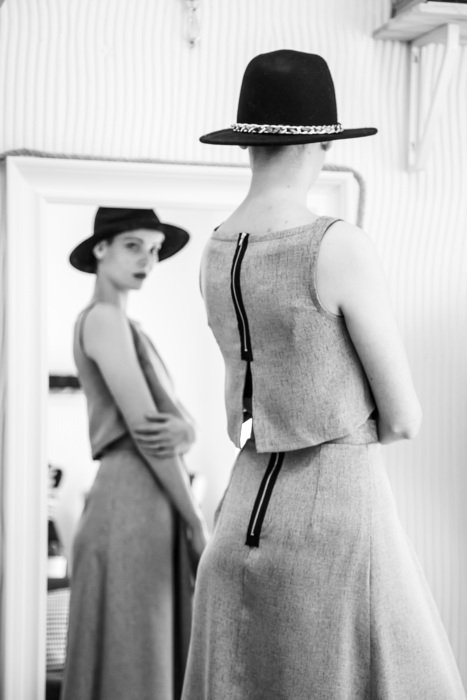 Girl in dress and hat near the mirror