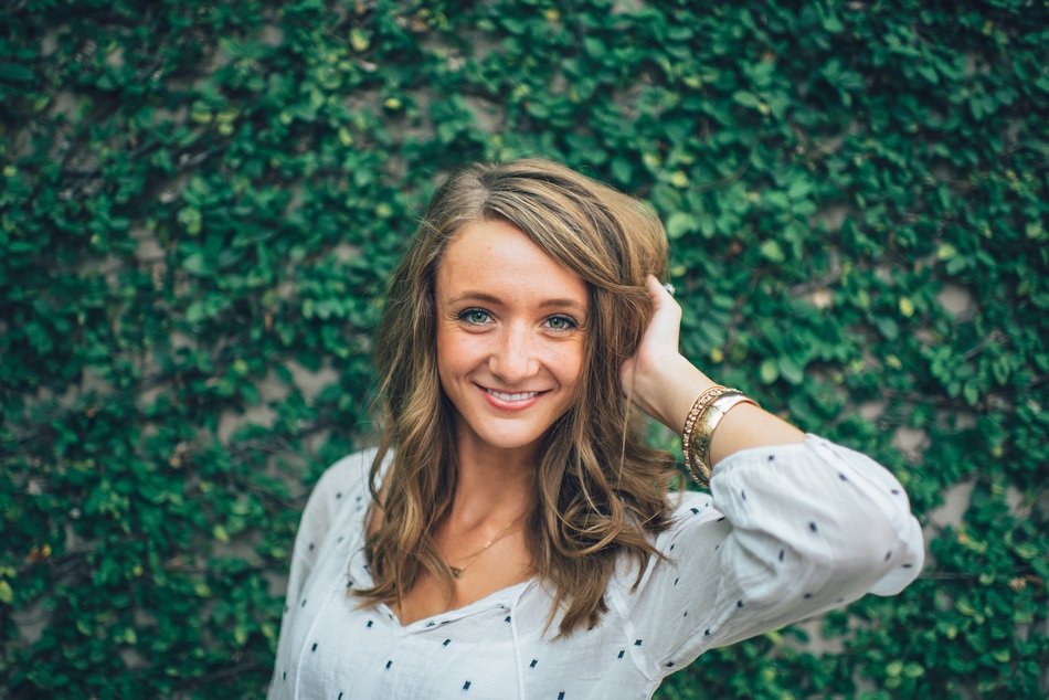 portrait of a happy girl on a background of green bush