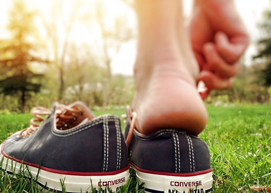 foot and Chucks Shoes on lawn