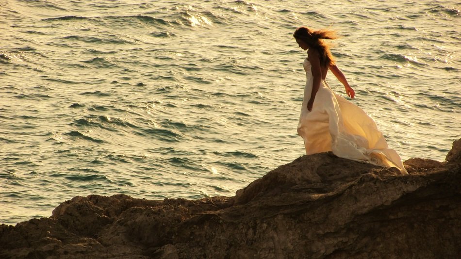 woman in romantic dress on the rock