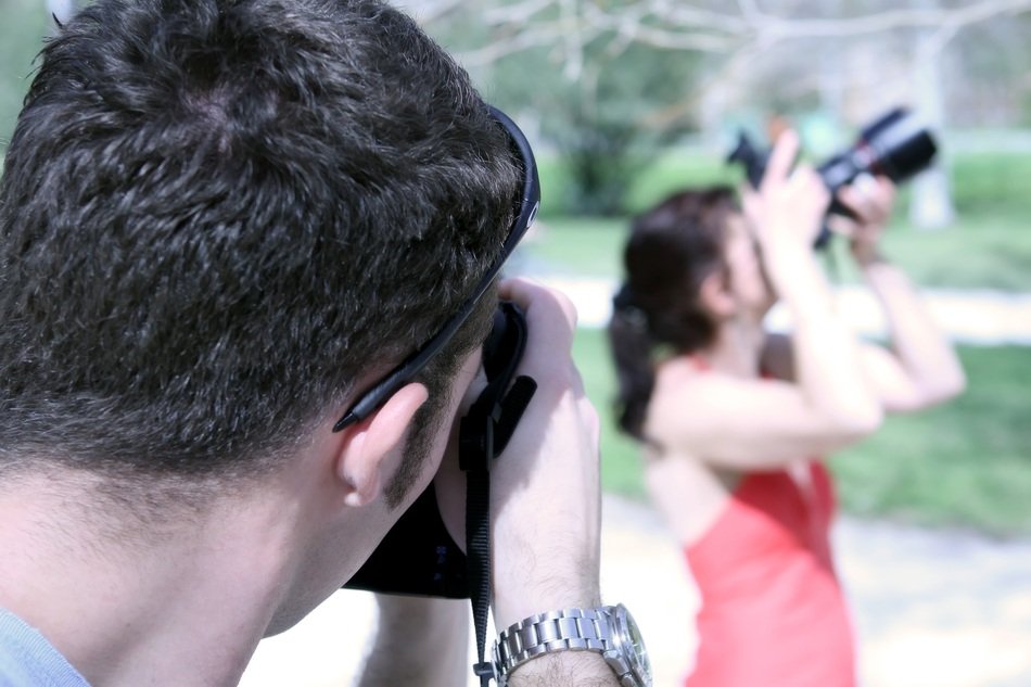 man and woman with cameras