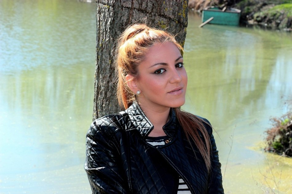 beautiful blonde near a tree on the lake