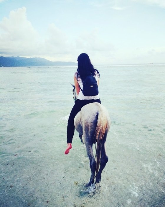 Woman on horse on the beach in Bali
