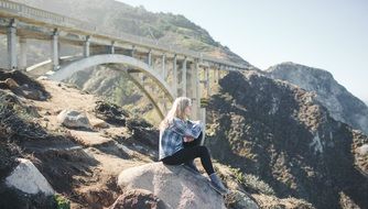 Lonely woman sitting on a hill