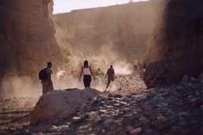 people on the sand in the canyon