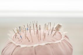 needles for sewing in pink fabric