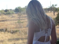 girl with white hair walks across the field