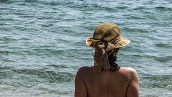 girl in brown hat by the sea
