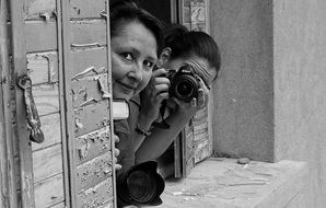 two Women taking shots from window