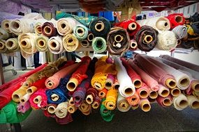 rolled up multi-colored fabrics on a market counter