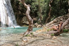 photo of a girl in a bikini near a waterfall in Greece