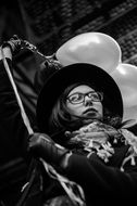 young Girl in Hat holding balloons above head