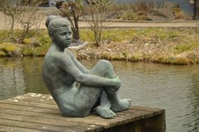 Stone woman statue on a river