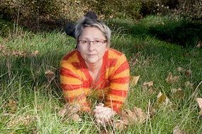 adult Woman in glasses lays on grass, Portrait