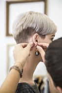 woman trying on an earring